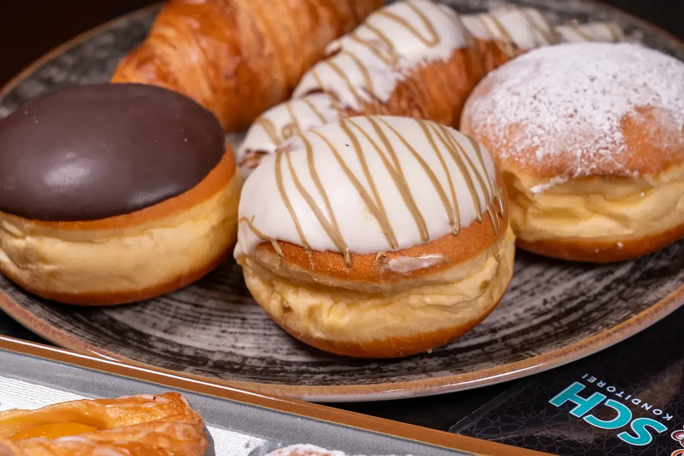 Krapfen und Donuts mit Schokolade und Staubzucker